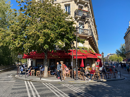 La terrasse aux stores rouges et or, vue sur la Seine